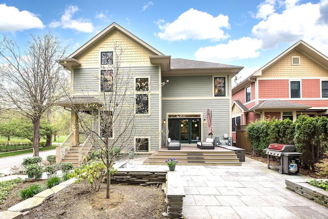 back of property with fence, a patio area, a deck, and french doors