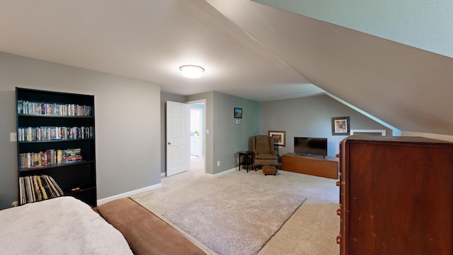 bedroom with baseboards, light colored carpet, and lofted ceiling