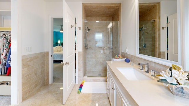 full bathroom featuring vanity, tile patterned flooring, tile walls, ensuite bathroom, and a stall shower