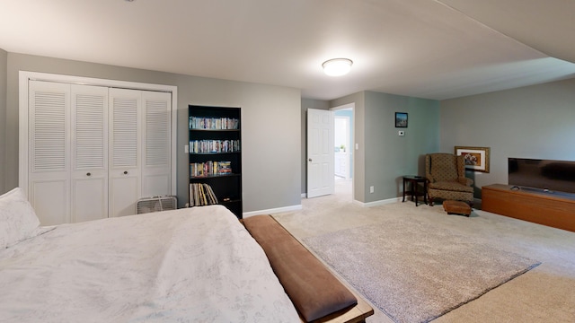 carpeted bedroom featuring baseboards and a closet