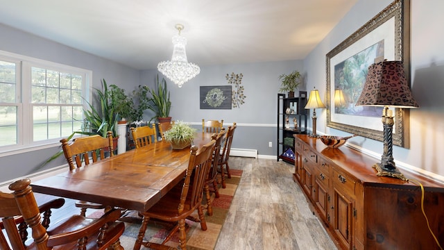 dining room featuring baseboard heating, baseboards, an inviting chandelier, and light wood-style flooring