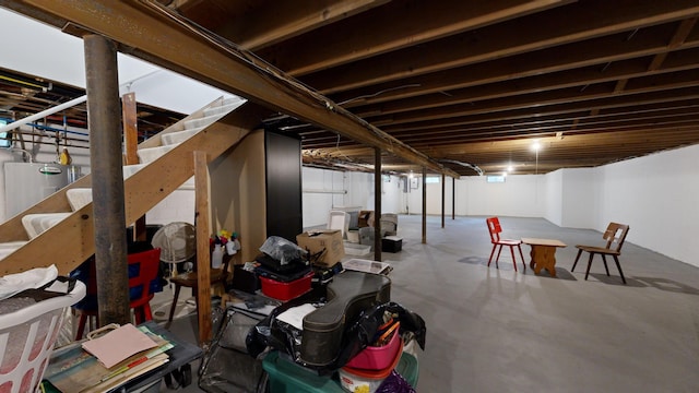 finished below grade area featuring stairway and water heater