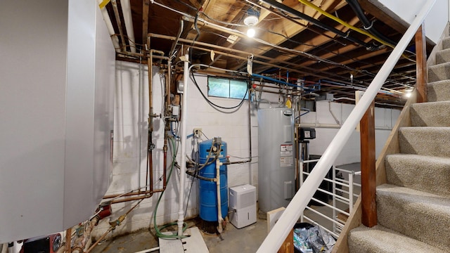 below grade area featuring stairs and electric water heater