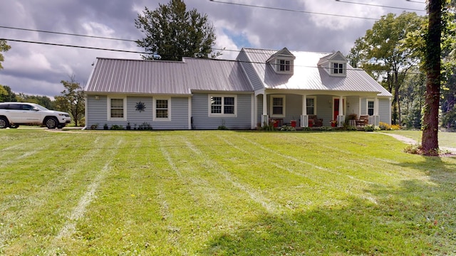 cape cod house featuring covered porch, a front yard, and metal roof