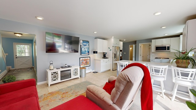living room with light tile patterned floors, baseboards, and recessed lighting