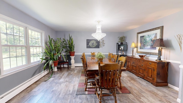 dining room featuring baseboards, baseboard heating, a baseboard heating unit, a chandelier, and light wood-style flooring