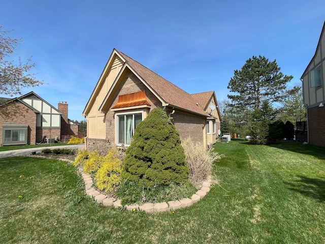 view of side of home with brick siding and a lawn