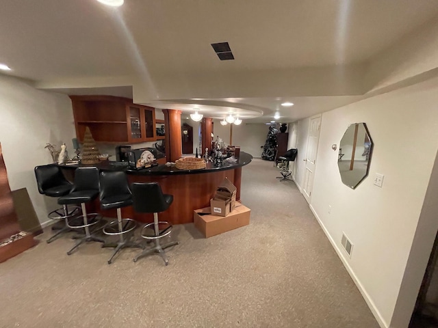 bar with bar area, baseboards, and visible vents