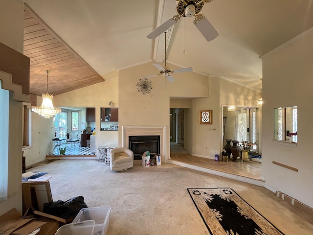 carpeted living area with beam ceiling, high vaulted ceiling, a glass covered fireplace, ceiling fan with notable chandelier, and baseboards