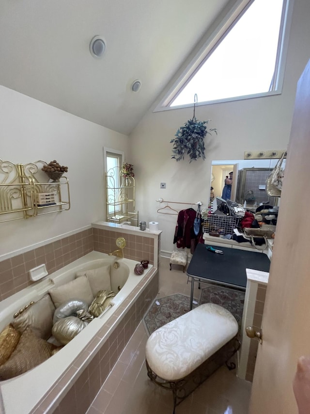 bathroom featuring high vaulted ceiling, vanity, and a bath
