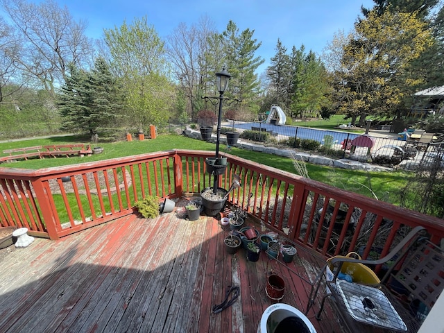 deck with a lawn and fence