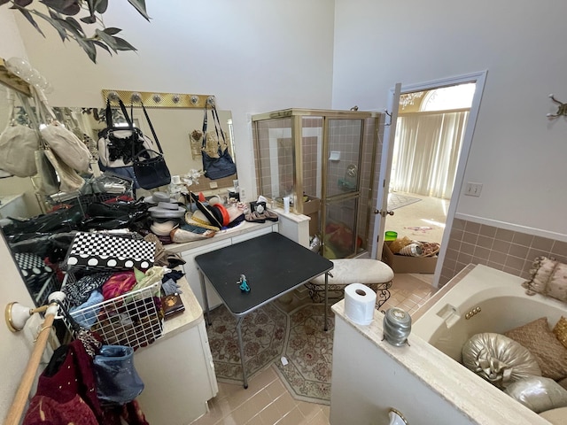 bathroom with tile patterned flooring, a garden tub, and a stall shower