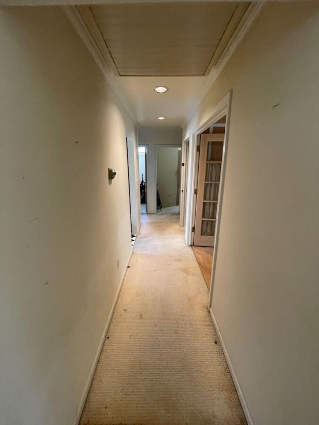 corridor featuring ornamental molding, baseboards, attic access, light colored carpet, and recessed lighting