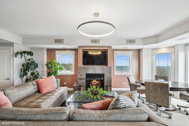 living room featuring baseboards, a fireplace, carpet flooring, and visible vents
