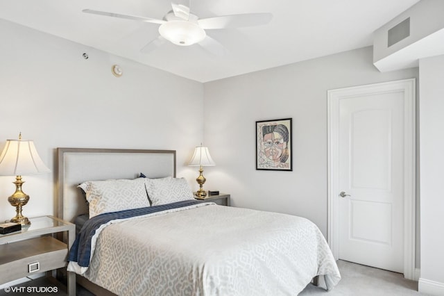 bedroom with a ceiling fan, visible vents, and light carpet