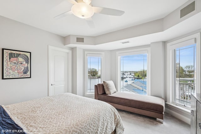 bedroom featuring visible vents, light carpet, multiple windows, and access to exterior