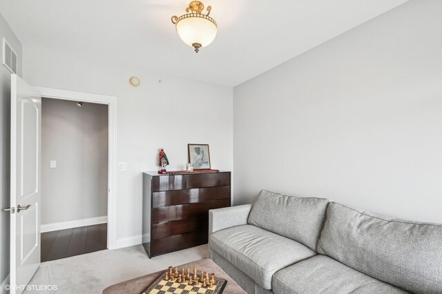 living room featuring baseboards, carpet, and visible vents