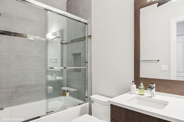 full bathroom with vanity, combined bath / shower with glass door, and toilet