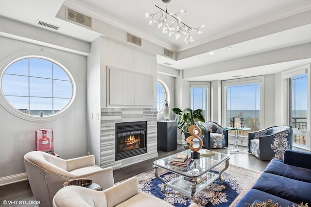 living room with crown molding, visible vents, and wood finished floors
