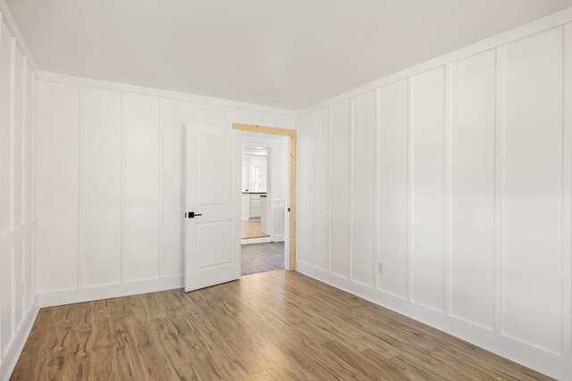 empty room with wood finished floors and a decorative wall