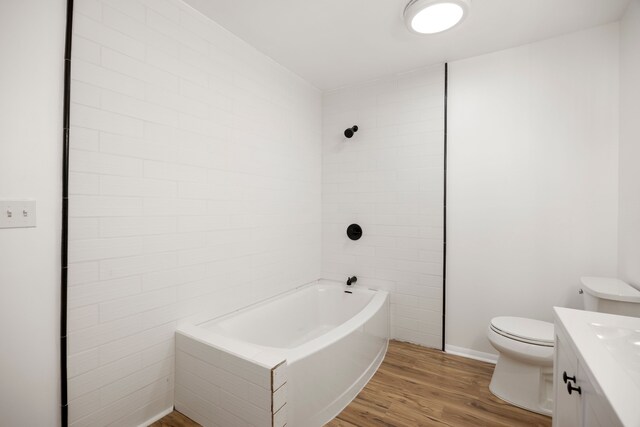 full bathroom featuring wood finished floors, vanity, baseboards, toilet, and  shower combination