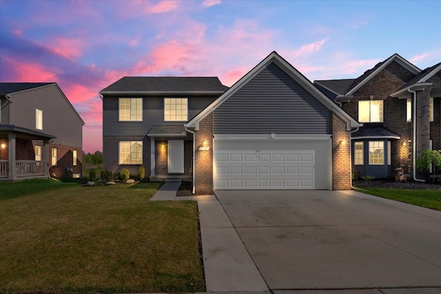 traditional home featuring a yard, concrete driveway, a garage, and brick siding