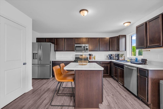 kitchen with a breakfast bar, light countertops, stainless steel appliances, and light wood-type flooring