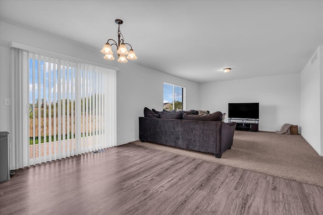 living area with an inviting chandelier, visible vents, and wood finished floors