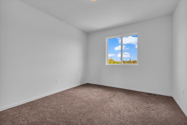 carpeted spare room featuring visible vents and baseboards