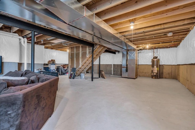 unfinished basement with stairway, heating unit, and gas water heater
