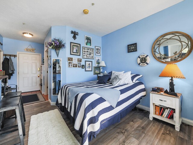 bedroom with baseboards and wood finished floors