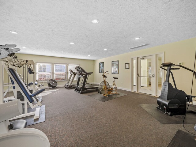 workout area with recessed lighting, a textured ceiling, and baseboards
