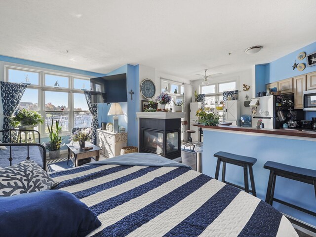 interior space with a multi sided fireplace and ceiling fan