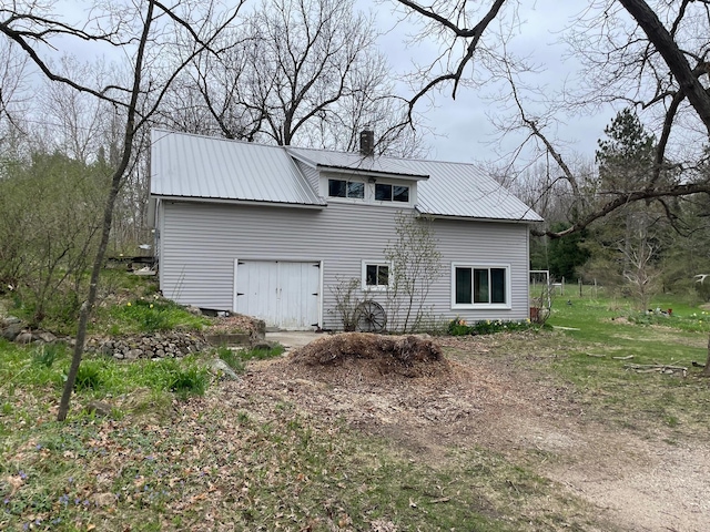 exterior space with a chimney and metal roof
