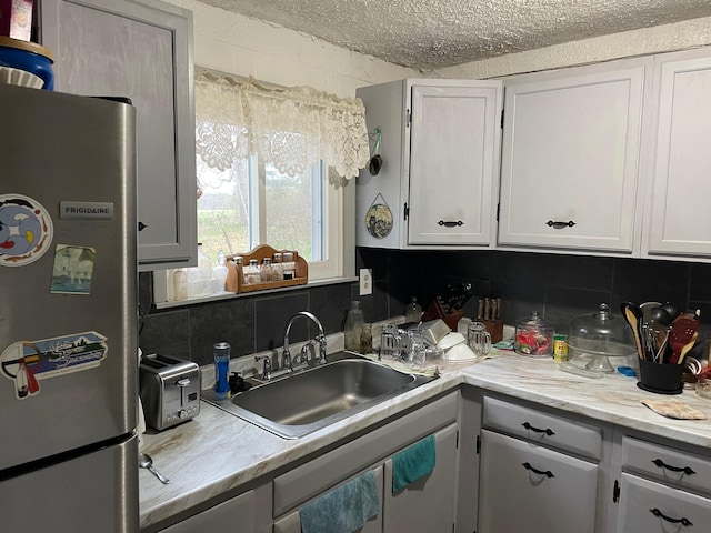 16206 Peters Farm Rd, Irons, MI 49644 - kitchen featuring freestanding refrigerator, decorative backsplash, a sink, and light countertops