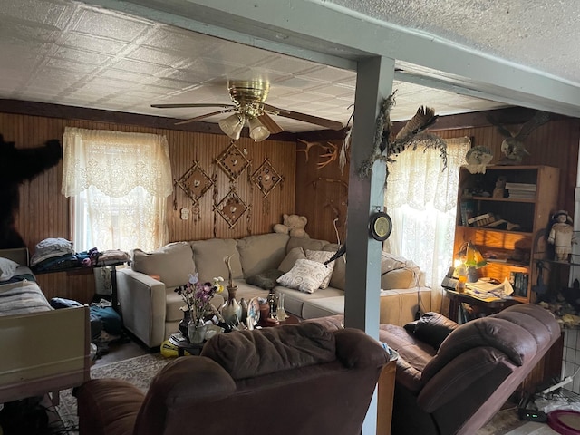16206 Peters Farm Rd, Irons, MI 49644 - living area with wooden walls, a ceiling fan, and a healthy amount of sunlight