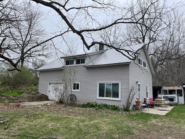 16206 Peters Farm Rd, Irons, MI 49644 - rear view of property featuring a garage, a chimney, a patio area, and metal roof