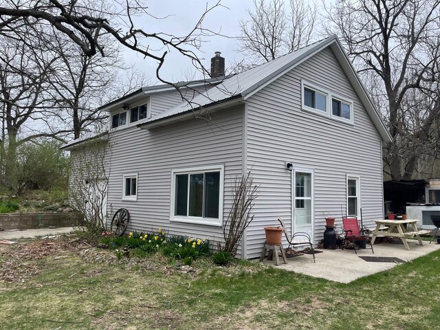 16206 Peters Farm Rd, Irons, MI 49644 - rear view of property featuring a chimney and a patio area