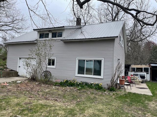16206 Peters Farm Rd, Irons, MI 49644 - rear view of house featuring a patio, an attached garage, and metal roof
