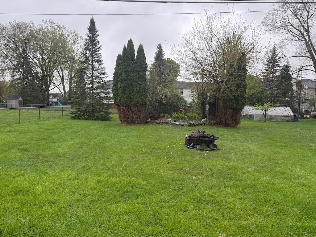 view of yard with a fire pit, an outbuilding, and a storage unit