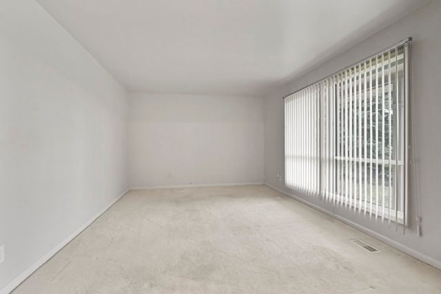 carpeted spare room with baseboards and visible vents