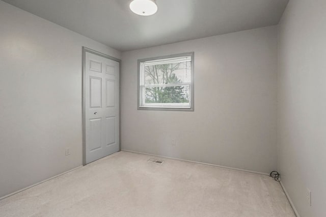 carpeted spare room with baseboards and visible vents