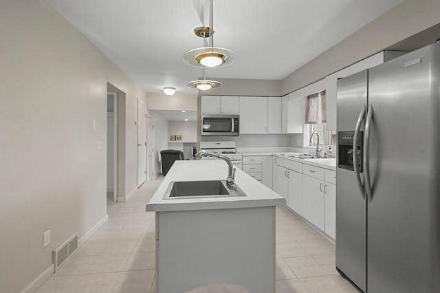 kitchen with a sink, appliances with stainless steel finishes, light countertops, and visible vents