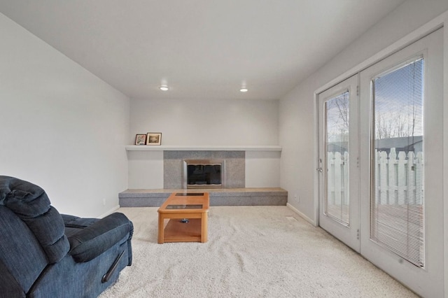 carpeted living room featuring baseboards, recessed lighting, and a premium fireplace