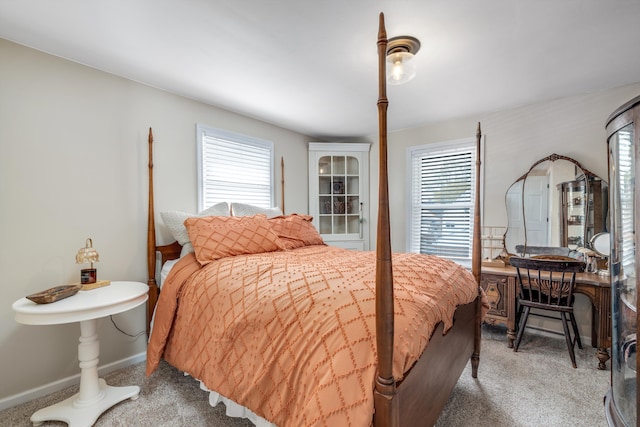 bedroom with baseboards, carpet, and multiple windows