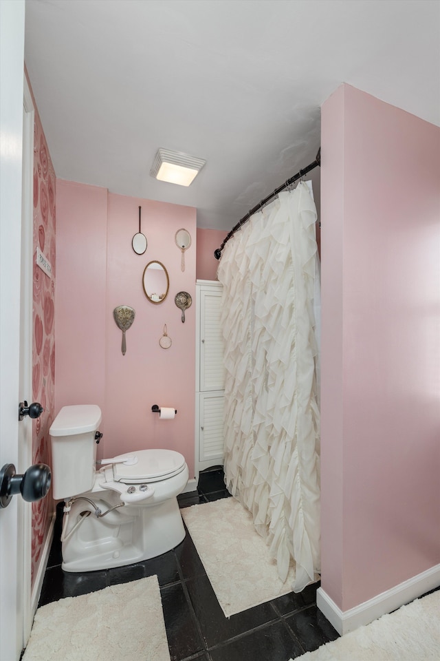 full bathroom featuring baseboards, toilet, and curtained shower
