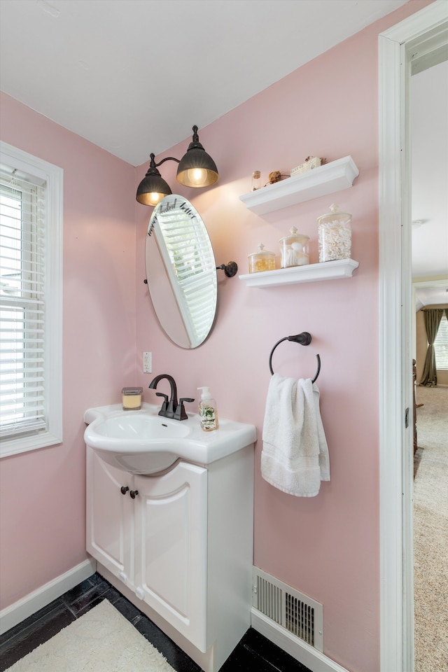 bathroom with visible vents, baseboards, and vanity