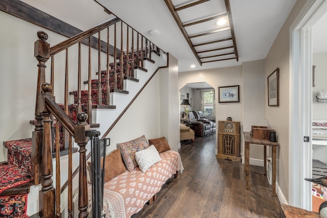 stairway featuring wood-type flooring, arched walkways, and recessed lighting