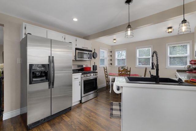 kitchen with appliances with stainless steel finishes, baseboards, dark wood finished floors, and white cabinetry