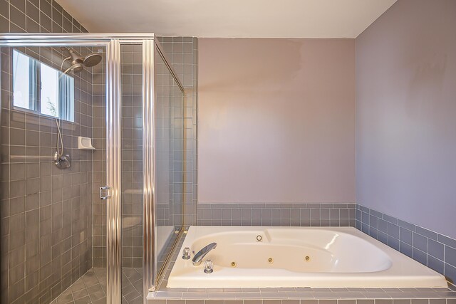 full bathroom featuring a shower stall and a jetted tub
